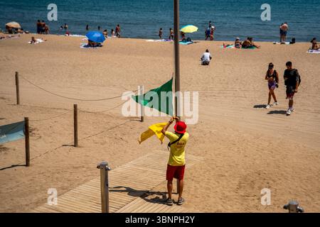 Barcelona, Spanien. Juli 2025. Ein Rettungsschwimmer ändert die Strandwarnflagge aufgrund der Anwesenheit eines Stachelrochen in der Nähe des Ufers. (Foto: Eric Renom/SOPA Images/SIPA USA) Credit: SIPA USA/Alamy Live News Stockfoto