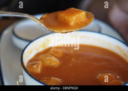 Warme Kürbissuppe mit gewürfeltem Gemüse, serviert in einer Schüssel Stockfoto