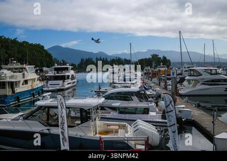 Die Coal Harbour Marina entlang der Seawall mit einem Harbour Air Wasserflugzeug, das bei Stanley Park, Vancouver, BC, landet. Stockfoto