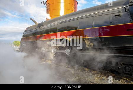 Eine Nahaufnahme einer großen restaurierten Dampfmaschine, die viel Dampf durchbläst Stockfoto
