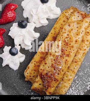 Pfannkuchen auf einem Teller mit Erdbeeren, Schlagsahne Stockfoto