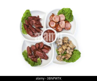 Geschnittene Würstchen, gebraten mit Gemüse und Gewürzen, isoliert auf weißem Hintergrund Stockfoto