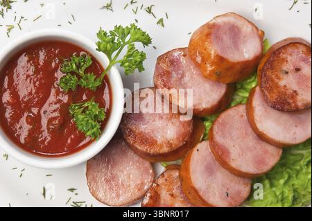 Würstchen mit Gemüse und Gewürzen gebraten Stockfoto