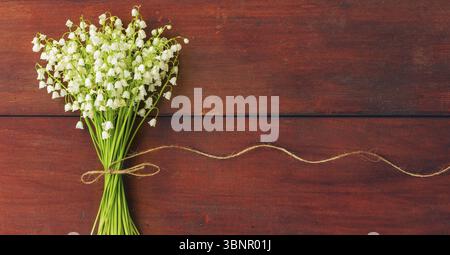 Weiße Blüten Lilien des Tales auf braunen Holzbrettern. Speicherplatz kopieren. Freier Speicherplatz für Text Stockfoto