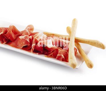 Food still-Life, Jamon Serrano, Prosciutto Crudo oder Parmaschinken und Brotstangen auf weißem Teller Stockfoto
