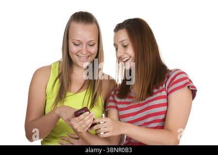 Porträt von hübschen jungen Frauen, die ihr Handy zusammen benutzen, isoliert auf weiß Stockfoto