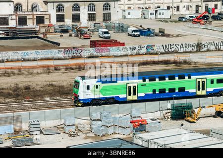 Mailand, Italien - 19. März 2025 : Trenord Zug vorbei an der Baustelle des Olympischen Dorfes in der Nähe von Fondazione Prada Stockfoto