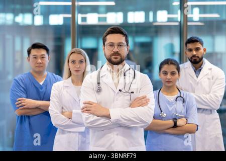 Gruppe von Gesundheitsfachleuten, die zusammenstehen, selbstbewusst und bereit für die Arbeit in einem modernen medizinischen Umfeld aussehen. Stockfoto