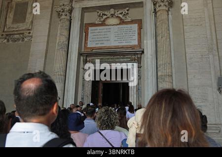 Menschenmassen laufen durch die heiligen Pforten (Porta Santa) der päpstlichen Basilika St. Peter im Vatikan (Petersdom). Die Türen werden nur alle 25 Jahre im Rahmen des Jubiläums in Rom geöffnet. Stockfoto