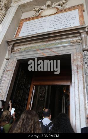 Menschenmassen laufen durch die heiligen Pforten (Porta Santa) der päpstlichen Basilika St. Peter im Vatikan (Petersdom). Die Türen werden nur alle 25 Jahre im Rahmen des Jubiläums in Rom geöffnet. Stockfoto