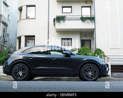 Bukarest, Rumänien – 11. Juni 2025: Nahaufnahme des schwarzen Autos Porsche Macan, das vor dem Haus geparkt wurde Stockfoto