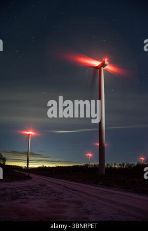 Windturbinen bei Nacht mit roten Fluglichtern, Paldiski Windpark unter Sternenhimmel, Estland. Stockfoto