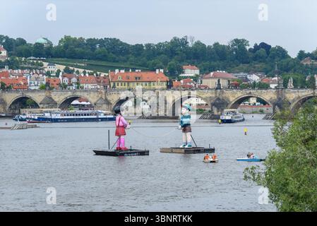 Zwei große aufblasbare Puppen, die die dritte Staffel der koreanischen Netflix-Serie Squid Game auf der Moldau im Zentrum von Prag, der Hauptstadt der Tschechischen Republik, fördern Stockfoto