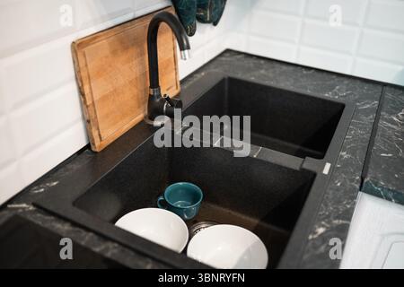 Haufen ungewaschenen, dreckigen Geschirrs im Waschbecken. Stockfoto