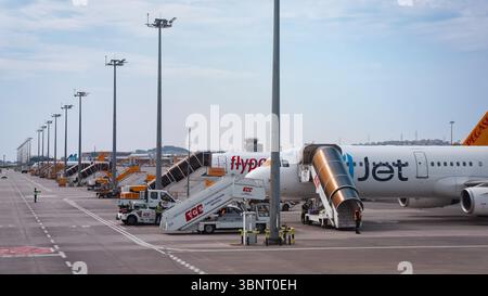 Zahlreiche Flugzeuge parken am Flughafen Istanbul, während das Bodenpersonal tagsüber Be- und Entladeaktivitäten durchführt. Stockfoto