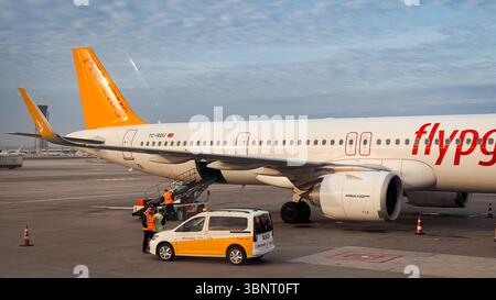 Die Bodencrew fährt am Flughafen Istanbul ein Flugzeug, wenn die Passagiere an einem sonnigen Tag an Bord ihrer Reise gehen. Stockfoto