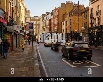 Vereinigtes Königreich, London, 14. Juli 2025. Geschäftige Commercial Street in Shoreditch mit Fahrzeugen und Fußgängern an einem sonnigen Winternachmittag Stockfoto