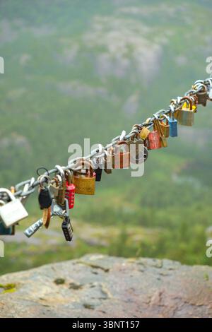 Liebesschlösser Preikestolen Norwegen, Vorhängeschlösser am Aussichtspunkt aus Metall-Kabel, Details zum Pulpit Rock Wanderweg, Lysefjord-Hintergrund, menschliche Spuren im Freien Stockfoto