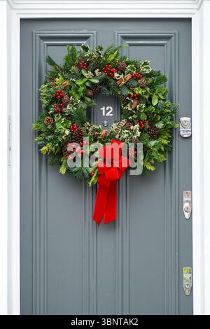 Ein dekorativer Weihnachtskranz hängt an der Haustür eines Hauses in Kensington, London, England, Großbritannien Stockfoto