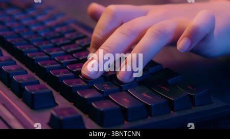 Nahaufnahme weibliche Hände Arme Schreiben Laptop mit Computer Maus Spielen virtuelles Videospiel Spielen Spielen Internet Streaming am Tisch im Nachtlicht Stockfoto