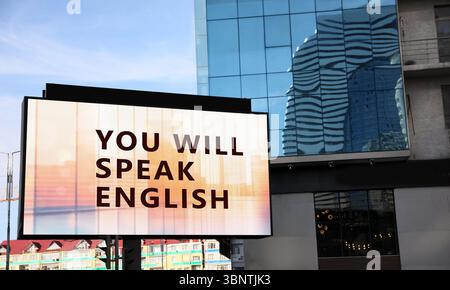 Sie sprechen englische Texte auf digitalen Plakaten in der Stadt. Sprachkurs Stockfoto