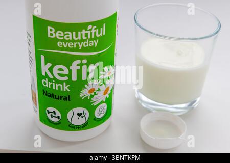 London. UK- 07.02.2025. Eine Flasche und ein Glas Kefir-Joghurtgetränk isoliert auf weiß. Stockfoto