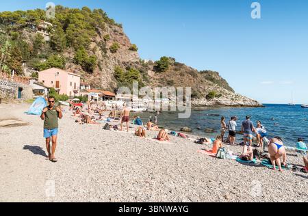 Taormina, Sizilien, Italien - 29. September 2024: Die Menschen entspannen am Strand von Isola Bella in Taormina. Stockfoto