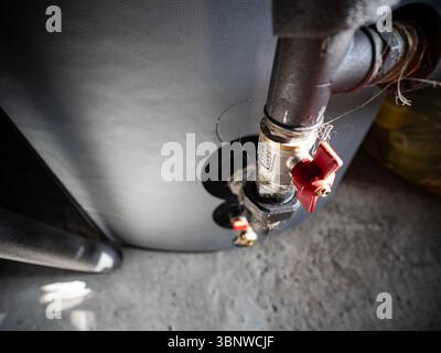 Roter Hebel zur Drucksteuerung in Rohren des Warmwasserkessels mit Klempnerhanfdichtung Stockfoto