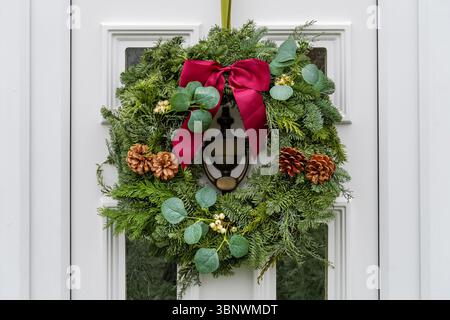 Ein dekorativer Weihnachtskranz hängt an der Haustür eines Hauses in Kensington, London, England, Großbritannien Stockfoto