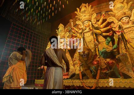 Howrah, Westbengalen, Indien - 3. Oktober 2022: Hindu-Priester verehren Göttin Durga mit Shaari, einem traditionellen bengalischen Frauenkleid. Stockfoto