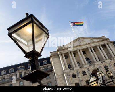 London, Großbritannien – 4. Juli 2025: Wetter in Großbritannien. Stadtprofis entspannen sich nach der Arbeit in der warmen Sommersonne vor der Bank of England, die zur Unterstützung der LGBT+-Community die Regenbogenfahne „Pride“ trägt. Quelle: Xiu Bao/Alamy Live News. Stockfoto