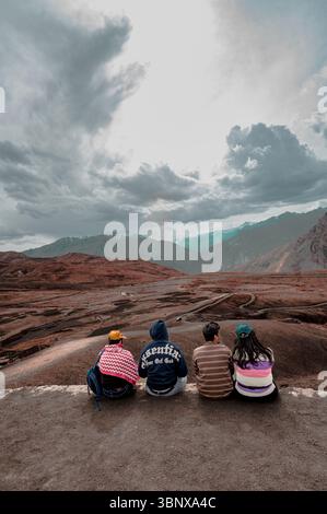 Eine Gruppe enger Freunde sitzt am Aussichtspunkt Langza und genießt die majestätische Aussicht auf den Himalaya – feiert Freundschaft, Zweisamkeit und Reiseerinnerungen. Stockfoto
