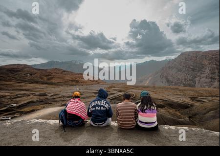 Eine Gruppe enger Freunde sitzt am Aussichtspunkt Langza und genießt die majestätische Aussicht auf den Himalaya – feiert Freundschaft, Zweisamkeit und Reiseerinnerungen. Stockfoto