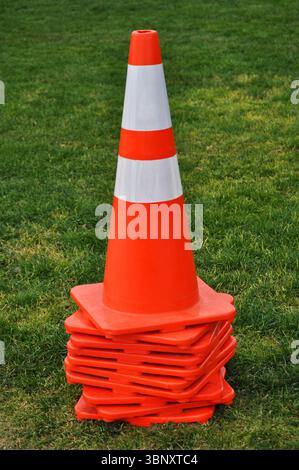 Orangefarbene Verkehrskegel auf dem Gras Stockfoto