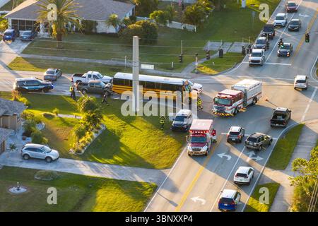 Auto- und Schulbusunfall auf der Autobahn in Florida. Rettungskräfte helfen Opfern eines Fahrzeugunfalls auf der Stadtstraße in den USA Stockfoto