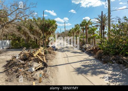 Trümmerhaufen auf der Straßenseite nach Hurrikan Milton auf der Manasota Key Road in Florida. Müll aus schwer beschädigten Häusern nach Sturmflut Stockfoto