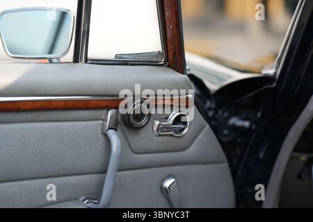 Die Türinnengriffe eines Oldtimers sind in einer klaren Ansicht gehalten und spiegeln das klassische Design und die erhaltenen Komponenten wider, die das einfache darstellen Stockfoto