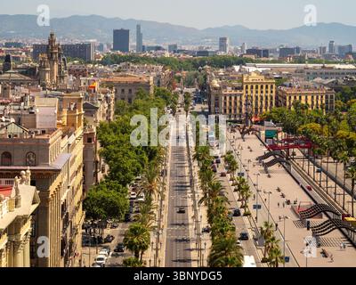 An einem sonnigen Sommertag in Barcelona, Spanien, blickt man auf die belebte, von Bäumen gesäumte Passeig de Colom in Richtung der Hügel. Stockfoto