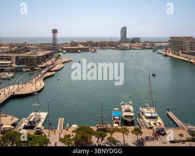 Blick über den Hafen von Port Vell in Barcelona, Spanien, mit dem Fußweg zur Rambla de Mar, den vertäuten Booten und dem berühmten W Hotel. Stockfoto