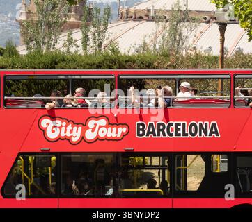 Touristen auf dem offenen Oberdeck eines roten „City Tour Barcelona“-Sightseeing-Busses. Barcelona, Spanien. Stockfoto