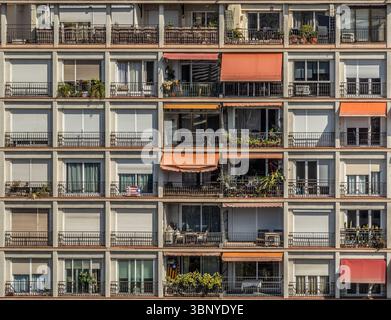Fassade eines typischen Wohnblocks in Barcelona, Spanien, mit einem Muster aus Balkonen, Fenstern und Fensterläden. . Stockfoto