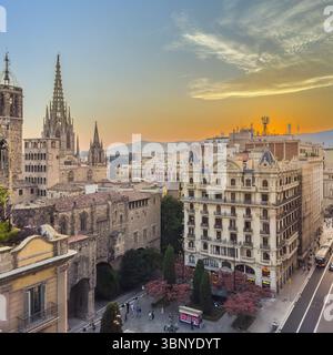 Die gotischen Türme der Kathedrale von Barcelona, beleuchtet bei Sonnenuntergang, über den historischen Dächern des gotischen Viertels, Barcelona, Spanien. Stockfoto