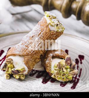 Stillleben, traditionelles italienisches Dessert Cannoli siciliani auf Teller Stockfoto