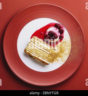 Stillleben, Napoleonkuchen mit Vanilleeis mit Kirschmarmelade Stockfoto