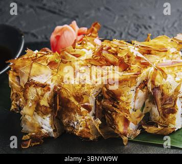 Stillleben, Sushi Bonito-Rolle auf einem dunklen Teller Stockfoto