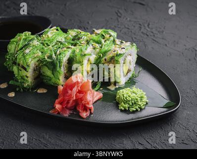 Stillleben, Sushi-Brötchen in Algen auf schwarzen Teller legen Stockfoto