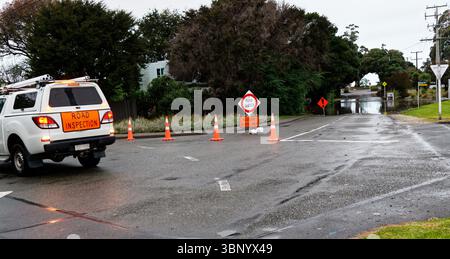 Überschwemmungen haben dazu geführt, dass Straßen gesperrt wurden und sich Wasser auf der Straße ansammelte. Ein Fahrzeug zur Straßenkontrolle ist draußen und über die Kontrolle der Straßen und der Überschwemmung si Stockfoto