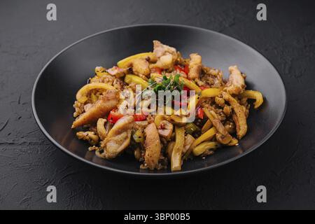 Stillleben, Chicken Bell Pfeffer Reis auf schwarzem Teller Stockfoto