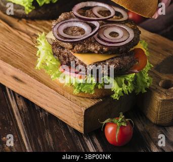 Stillleben von Lebensmitteln, Nahaufnahme weiblicher Küche frischer leckerer Burger Stockfoto