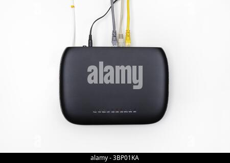 Schwarzes gpon-Teilnehmerterminal mit Anschluss an ein Glasfasernetzwerk und verschiedene Geräte mit lan-Kabeln auf weißem Hintergrund von oben Stockfoto